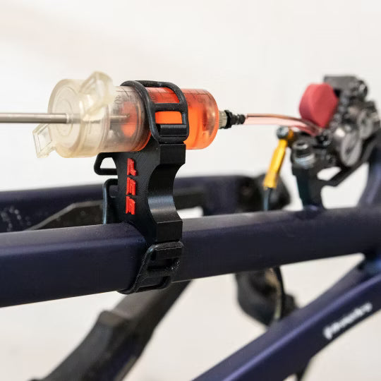 SUPERSONIC PARTS spuithouder kit hydraulische remmen ontluchten met rode houders en rubberen straps in gebruik met olie
