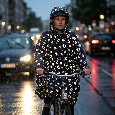 REFLECTIVE BERLIN regenponcho gedragen op de fiets in het donker met regen