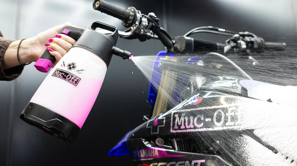 Fietser reinigt motor met Muc-Off schuimsproeier zonder hogedrukreiniger