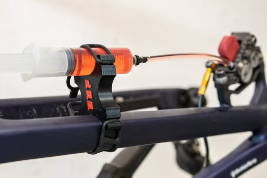 SUPERSONIC PARTS spuithouder kit hydraulische remmen ontluchten met rode houders en rubberen straps horizontaal geplaatst