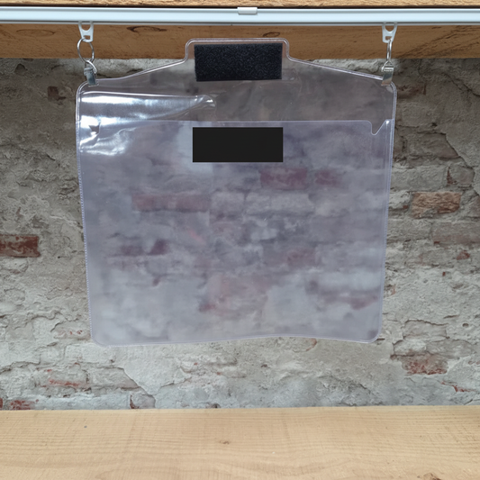 Transparante waterdichte PVC tas met zwart label hangend aan rail met metalen haken