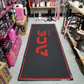 Acebikes Moto Carpet XL uitgerold in garage – zwarte motormat met rood ACE Bikes logo